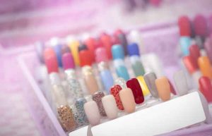 Colorful artificial Nails in nail salon shop. Set of false nails for customer to choose color for manicure or pedicure in nail salon and spa shop. Nails art and design. Sample nail polish palette.